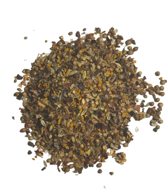African BBQ spice blend with crushed spices and seeds on a white background