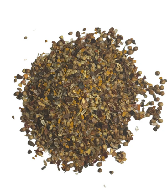 African BBQ spice blend with crushed spices and seeds on a white background