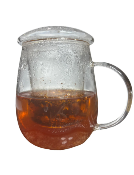 Glass mug filled with warm amber rooibos tea gently steeping under a lid, showcasing its rich color and calming aroma.