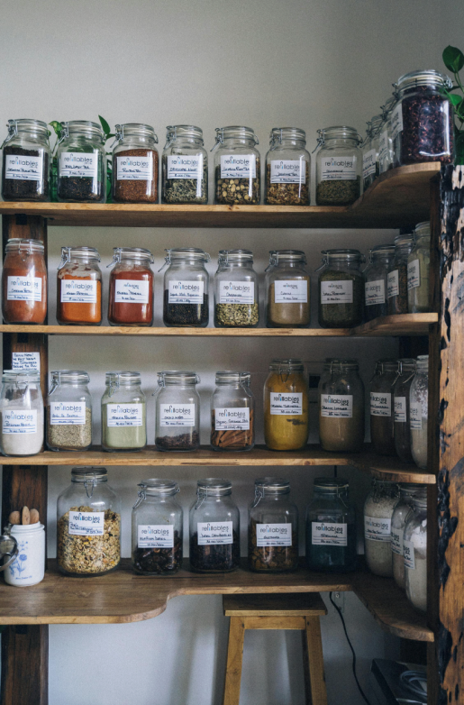 This photo shows a neatly arranged spice and tea jars on multiple shelves.