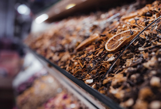 A close-up of dried orange slices and assorted spices arranged beautifully on a wooden surface.