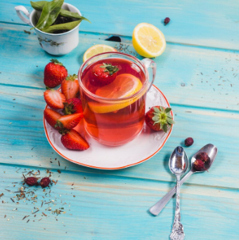 Clear glass mug with vibrant fruit tea.