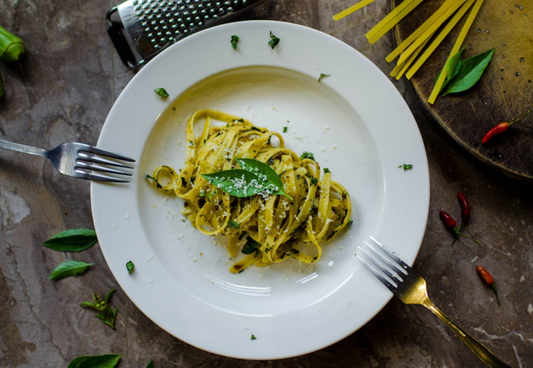 Pasta dish topped with grated Parmesan, garnished with herbs.