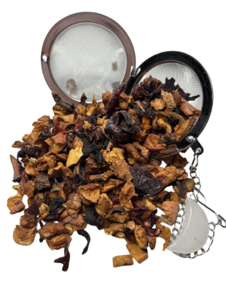 A dried fruit tea blend with hibiscus, apple pieces, and mixed botanicals spilling from a metal tea infuser.
