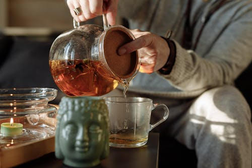 Woman pouring brewed tea into a cup as part of her tea ritual.